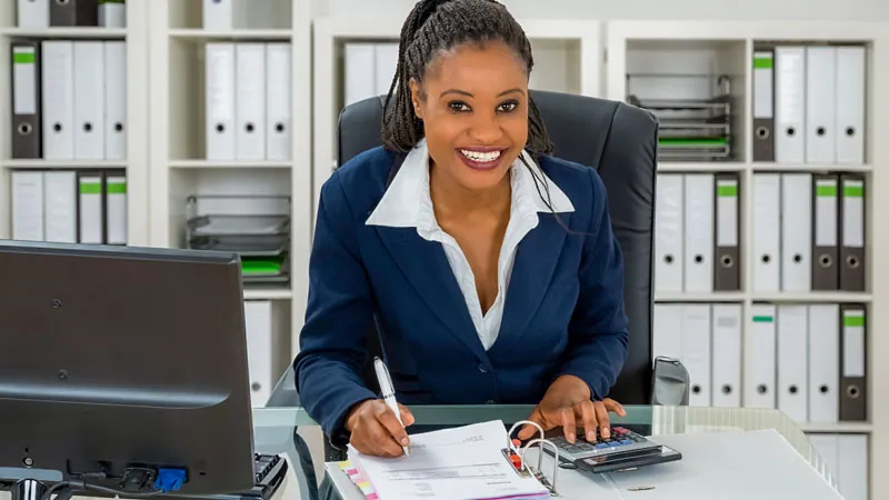 Mulher jovem, negra, profissional de contabilidade trabalhando no escritório.