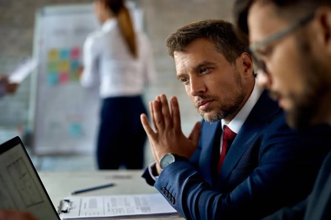 Two experienced, worried executives sitting at a desk analyzing office data