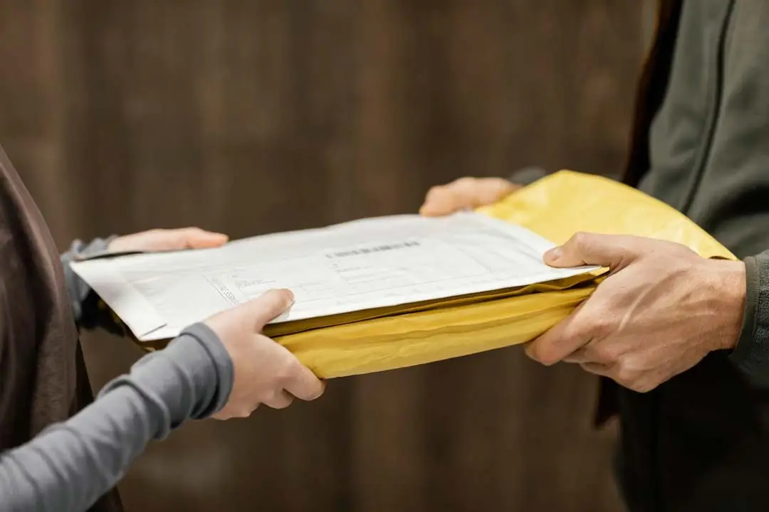 Executive hands over documents and envelope to businesswoman
