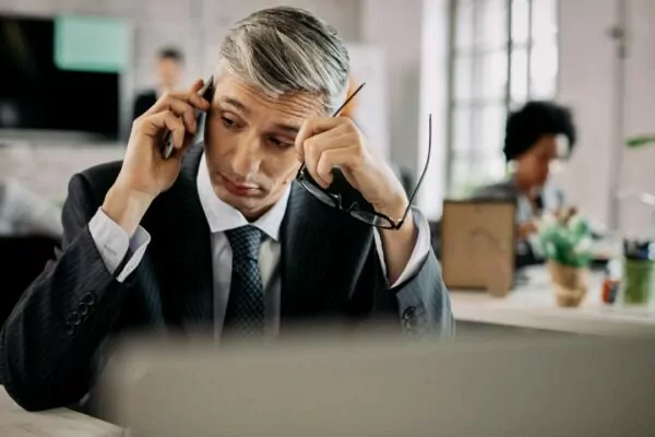 hombre de negocios hablando por el móvil sentado a la mesa de la oficina