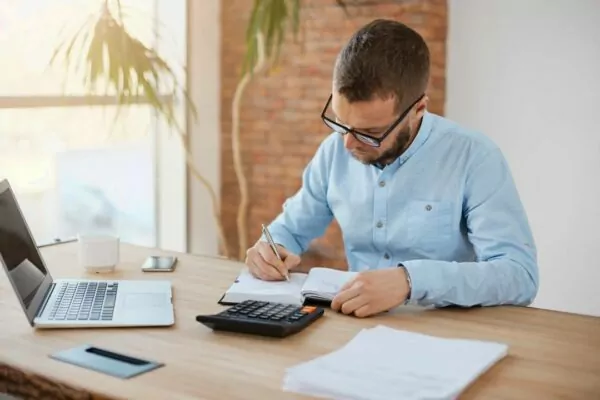 joven-caucásico-hombre-directivo-gafas-sentado-en-compañía-oficina