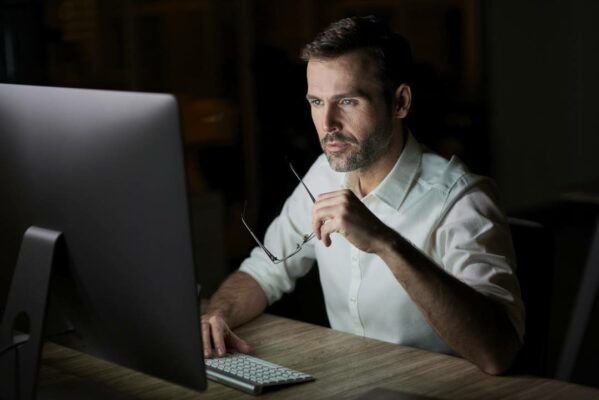 homem-focado-usando-computador-noite