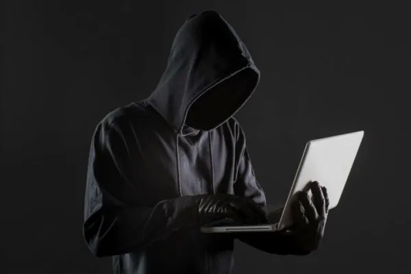side-man-hacker-with-laptop-gloves