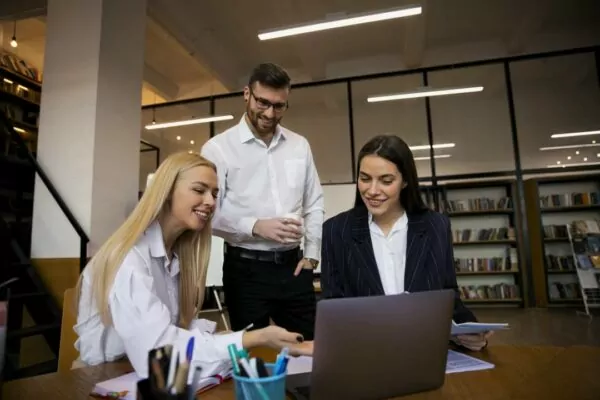 man-and-two-women-in-company-looking-at-notbook
