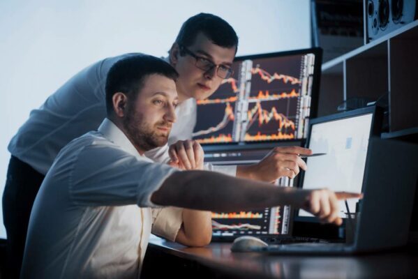 dois homens no escritorio analisando dados