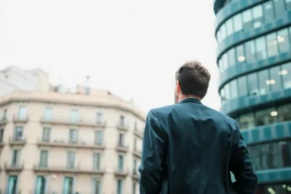 man on the street looking at building