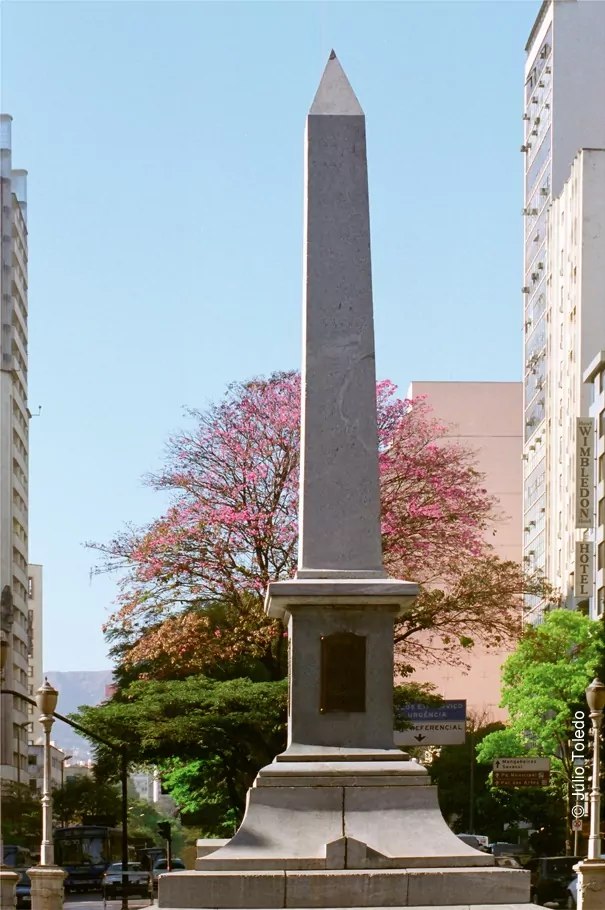 Pirulito da Praça Sete, marco zero de Belo Horizonte, com ipês floridos e prédios ao redor